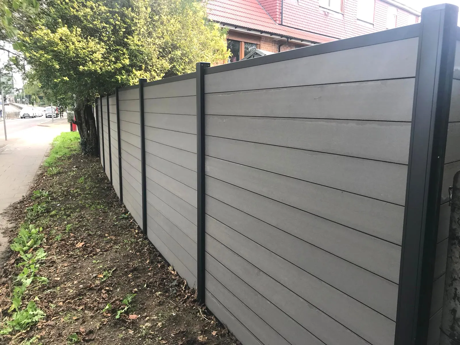 Grey composite fencing along a West London street