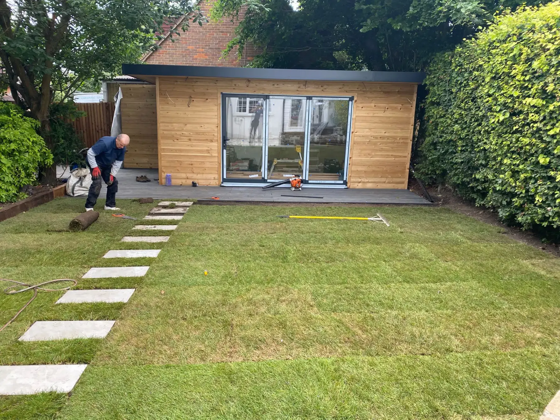Laying stepping stones across a new lawn to a garden office